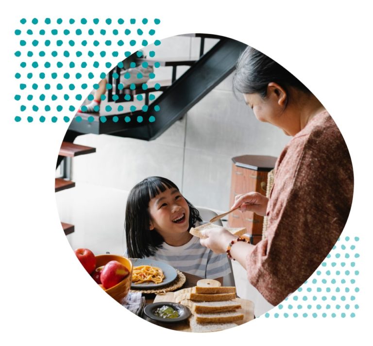 mother and daughter laughing and enjoying a meal